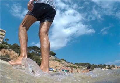 Ein Mann spaziert am Strand von Portals Nous auf Mallorca entlang. Das Mittelmeer erwärmt sich einer Studie zufolge immer schneller und wird dabei auch immer salziger.

