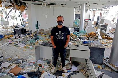Ein Mann steht in seinem zerstörten Büro in Beirut
