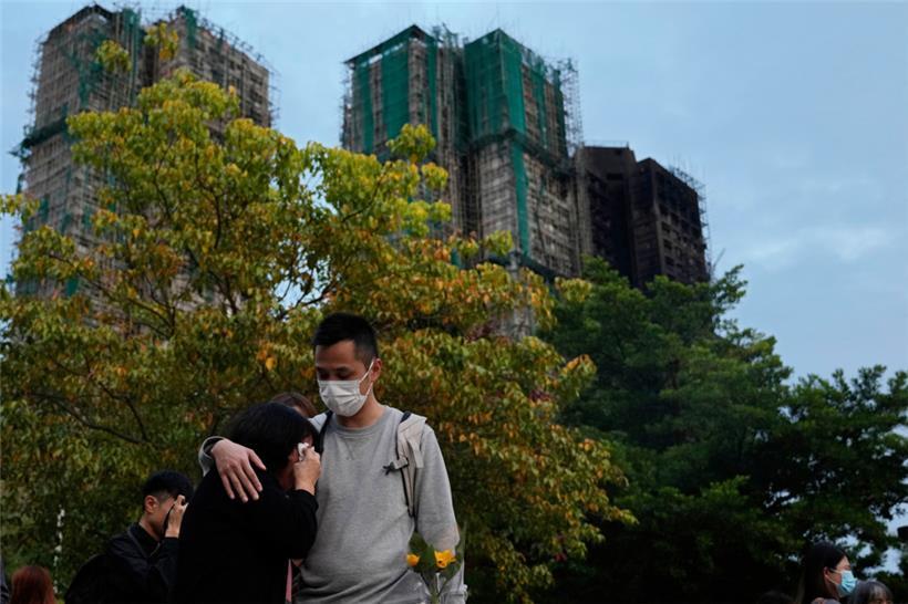 Ein Mann tröstet eine Frau am Ort des tödlichen Brandes im Wang Fuk Court, einer Wohnsiedlung im Stadtteil Tai Po in den New Territories von Hongkong
