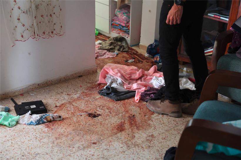 Ein Mann untersucht am 19. Oktober 2023 nach dem Angriff der Hamas-Kämpfer vom 7. Oktober Blutflecken auf dem Boden eines Hauses im Kibbuz Nir Oz an der Grenze zum Gaza-Streifen
