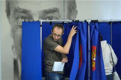 Ein Mann verlässt eine Wahlkabine in einem Wahllokal während der dreitägigen Regional- und Kommunalwahlen
