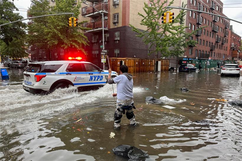 Ein Mann versucht im Stadtbezirk Brooklyn einen Abfluss im Hochwasser zu reinigen
