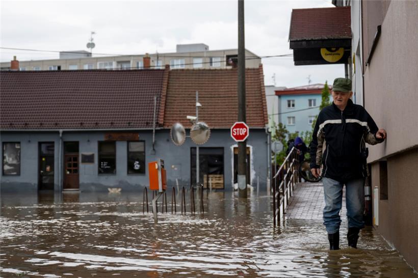 Ein Mann watet durch eine überflutete Straße in Litovel in Tschechien. Ganze Regionen leiden unter einem Jahrhunderthochwasser
