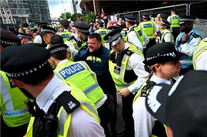 Ein Mann wird während der Demonstration vor dem Britannia-Hotel im Londoner Stadtteil Canary Wharf verhaftet
