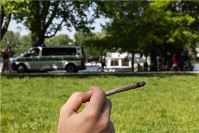 Ein Mensch hält einen Joint in der Hand – nach dem Willen der Gelsenkirchener Polizei sollten auch mehr Fußballfans zur Tüte greifen
