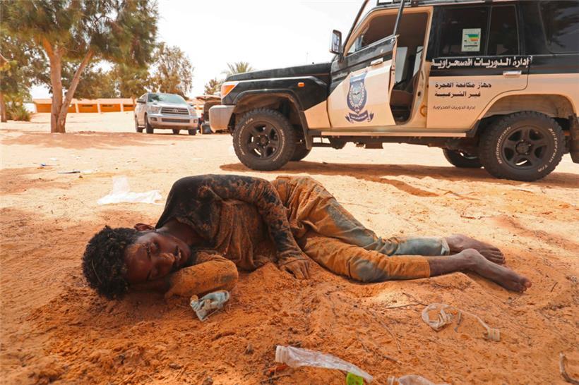 Ein Migrant kollabiert, als er in Al-Assah ankommt, im Niemandsland zwischen Libyen und Tunesien. Das Foto ist vom 30. Juli 2023.
