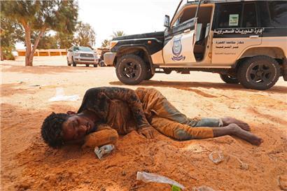 Ein Migrant kollabiert, als er in Al-Assah ankommt, im Niemandsland zwischen Libyen und Tunesien. Das Foto ist vom 30. Juli 2023.
