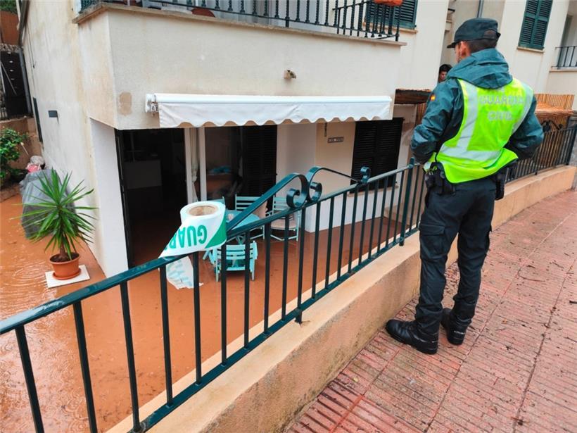 Ein Mitarbeiter der Guardia Civil blickt auf ein durch Starkregen überflutetes Haus in Puerto de Sóller
