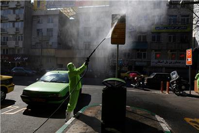 Ein Mitarbeiter der Stadt Teheran desinfiziert in Schutzanzug ein Bushaltestellenschild. Die offizielle Zahl der Coronavirus-Toten und -Infizierten im Iran ist nach Angaben des Gesundheitsministeriums erneut gestiegen
