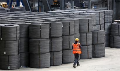 Ein Mitarbeiter geht an Drahtrollen in den Elbe-Stahlwerken Feralpi in Riesa vorbei: Die Wirtschaft in Ostdeutschland dreht besser als gedacht
