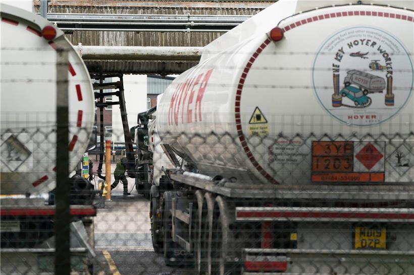 Ein Mitarbeiter in Warnkleidung befüllt am Valero Manchester Terminal Kraftstofftankwagen. Im Vereinigten Königreich sind derzeit viele Tankstellen ohne Benzin. Hintergrund ist ein Mangel an Lastwagenfahrern.
