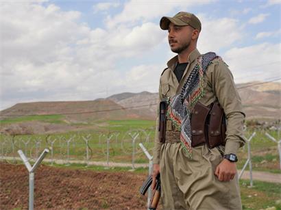 Ein Mitglied der Demokratischen Partei Iranisch-Kurdistans (PDKI) steht an einem Kontrollpunkt, der zum Stützpunkt im Stadtteil Koya in Erbil führt