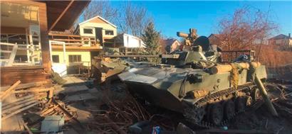 Ein Panzer steht neben von der russischen Armee zerstörten Häusern in der Nordukraine
