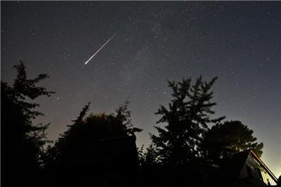Ein Perseidenmeteor zieht über den Himmel
