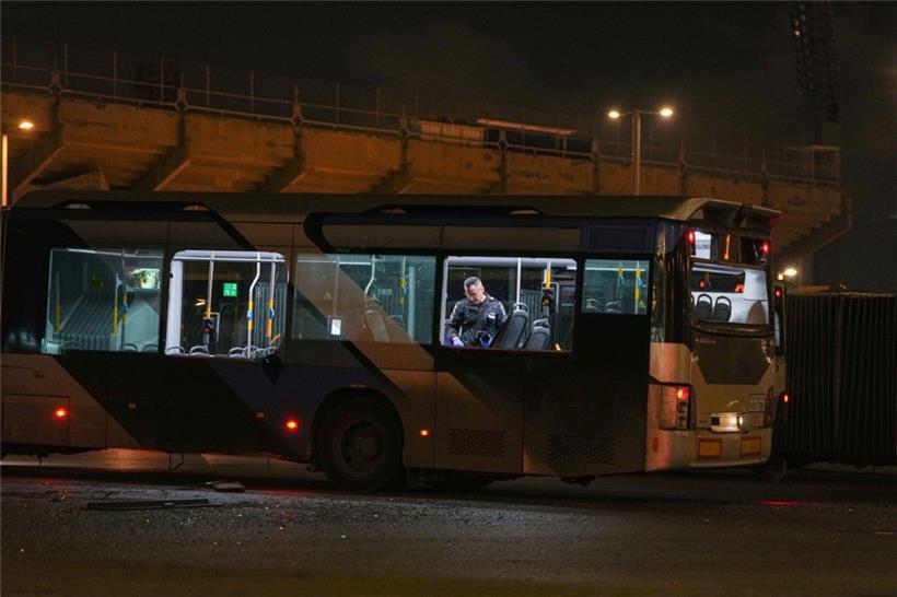 Ein Polizeibeamter inspiziert einen Bus. Polizeiangaben zufolge sind mehrere Busse in einem südlichen Vorort von Tel Aviv explodiert. 
