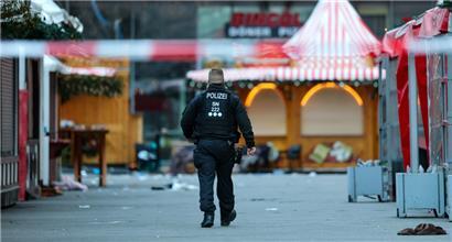 Ein Polizist geht hinter einer Absperrung am Magdeburger Weihnachtsmarkt
