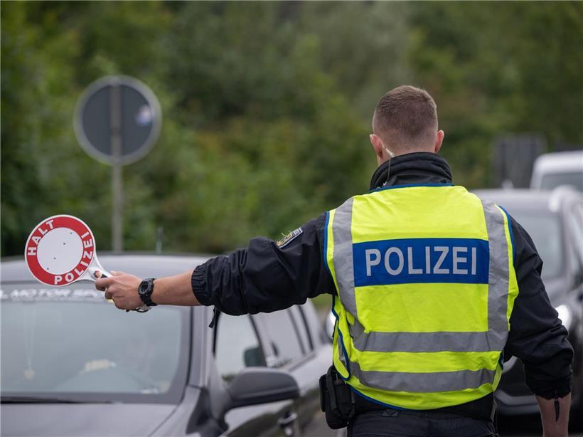 Polizist kontrolliert Fahrzeuge an deutscher Grenze bei Grenzkontrolle und Verkehrssicherheit
