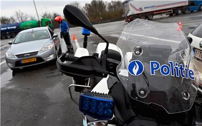  Ein Polizist kontrolliert einen Autofahrer an der Grenze Belgiens zu den Niederlanden
