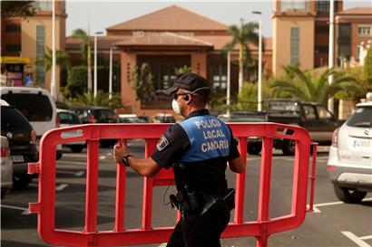 Ein Polizist setzt eine Sperre, die den Zugang zum Hotel H10 Costa Adeje Palace auf Teneriffa blockiert
