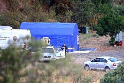 Ein Polizist steht am Dienstag neben einem Auto und einem Zelt in der Nähe von Barragem do Arade in Portugal. Die portugiesische Polizei sagte, sie werde die Suche nach Madeleine McCann in den nächsten Tagen wieder aufnehmen.
