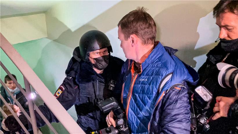 Ein Polizist steht vor Fotografen vor einer Tür der Wohnung, wo Oleg Nawalny, Bruder des inhaftierten Kremlgegners Alexej Nawalny lebt
