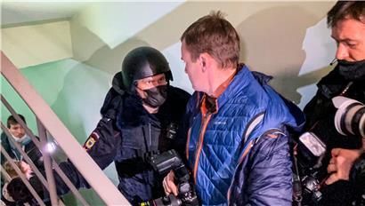Ein Polizist steht vor Fotografen vor einer Tür der Wohnung, wo Oleg Nawalny, Bruder des inhaftierten Kremlgegners Alexej Nawalny lebt
