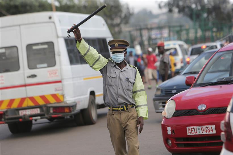 Ein Polizist trägt eine Gesichtsmaske, während er den Verkehr, regelt. Simbabwe hat seine Grenzen für den nicht lebensnotwendigen Verkehr geschlossen, um die Verbreitung des neuen Coronavirus zu begrenzen. 
