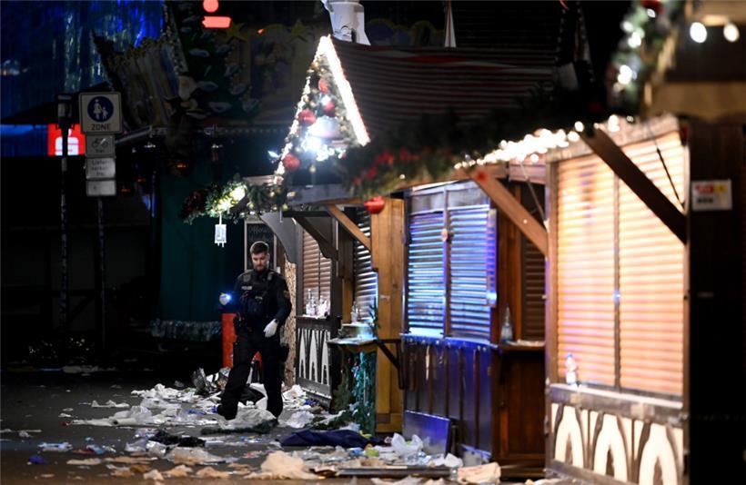Ein Polizist untersucht den Tatort auf dem Weihnachtsmarkt

