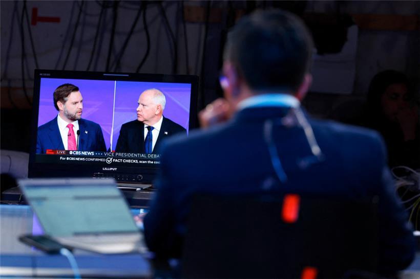 Ein Reporter schaut sich im „Spin Room“ in New York die Debatte zwischen JD Vance und Tim Walz auf einem Monitor an
