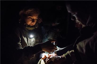 Ein Sanitäter versorgt einen verletzten Soldaten an einer Krankenstation, nachdem er aus einer von den Russen angegriffenen Stellung evakuiert wurde

