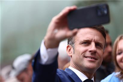 Ein Selfie zum Debakel: Emmanuel Macron macht ein Selfie mit Anhängern, nachdem er seine Stimme abgegeben hat

