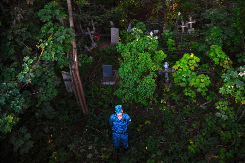 Ein Soldat der russischen Nationalgarde steht Wache auf dem Friedhof Porochowskoje
