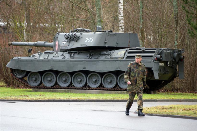 Ein Soldat läuft 2012 auf dem Gelände der Graf-Stauffenberg-Kaserne an einem ausgestellten Kampfpanzer vom Typ Leopard 1 A4 vorbei
