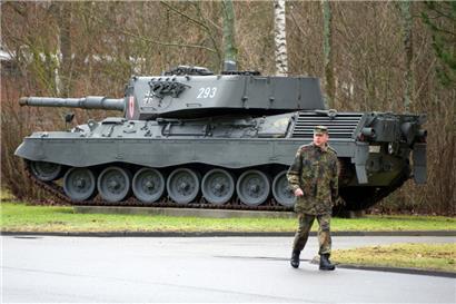 Ein Soldat läuft 2012 auf dem Gelände der Graf-Stauffenberg-Kaserne an einem ausgestellten Kampfpanzer vom Typ Leopard 1 A4 vorbei
