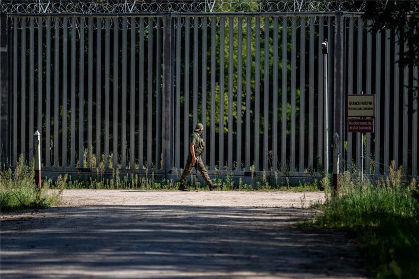 Ein Soldat läuft am Grenzzaun auf der polnischen Seite zu Belarus entlang
