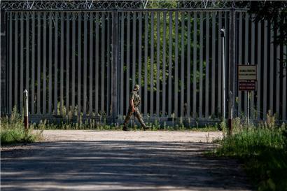 Ein Soldat läuft am Grenzzaun auf der polnischen Seite zu Belarus entlang
