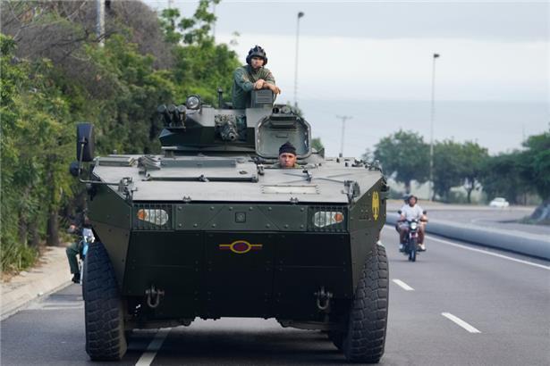 Ein Soldat steht auf einem gepanzerten Fahrzeug auf der Autobahn, die vom internationalen Flughafen nach Caracas führt
