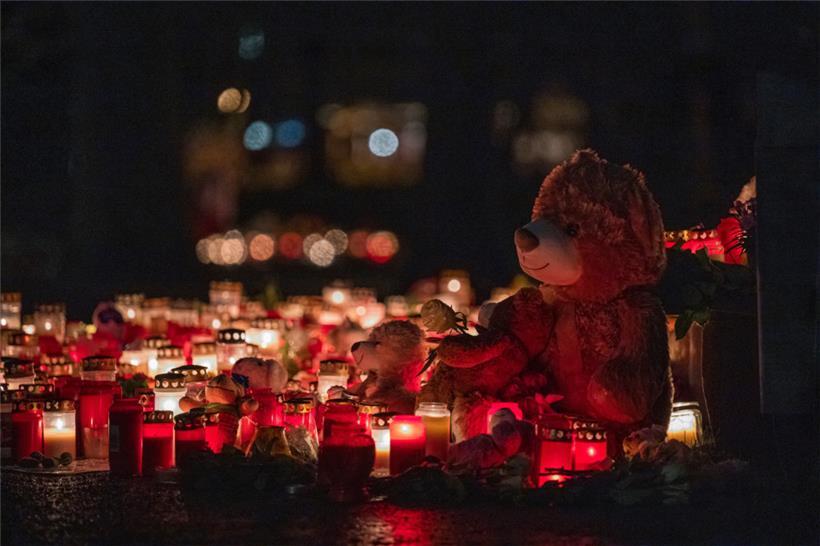 Ein Teddybär steht zusammen mit zahlreichen Kerzen auf dem Boden und erinnert an den tödlichen Messerangriff in Aschaffenburg
