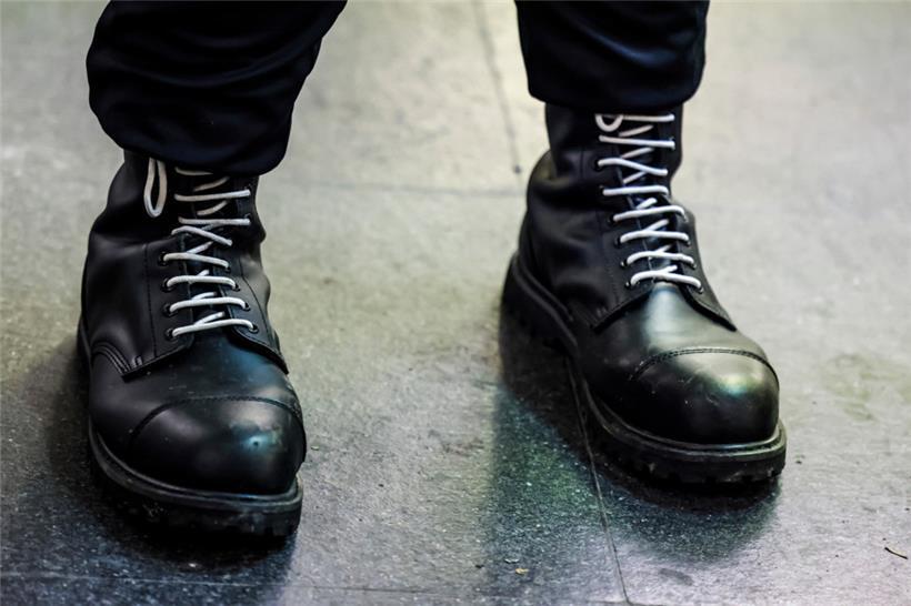 Ein Teilnehmer einer rechtsextremen Kundgebung trägt schwarze Springerstiefel mit weißen Schnürriemen, einem weit verbreitetem Symbol der rechten Szene

