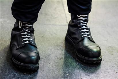 Ein Teilnehmer einer rechtsextremen Kundgebung trägt schwarze Springerstiefel mit weißen Schnürriemen, einem weit verbreitetem Symbol der rechten Szene
