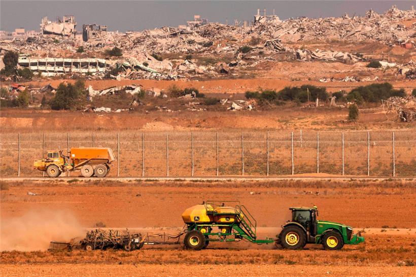 Ein Traktor bearbeitet vor dem Grenzzaun zum Gazastreifen ein Feld in Südisrael 
