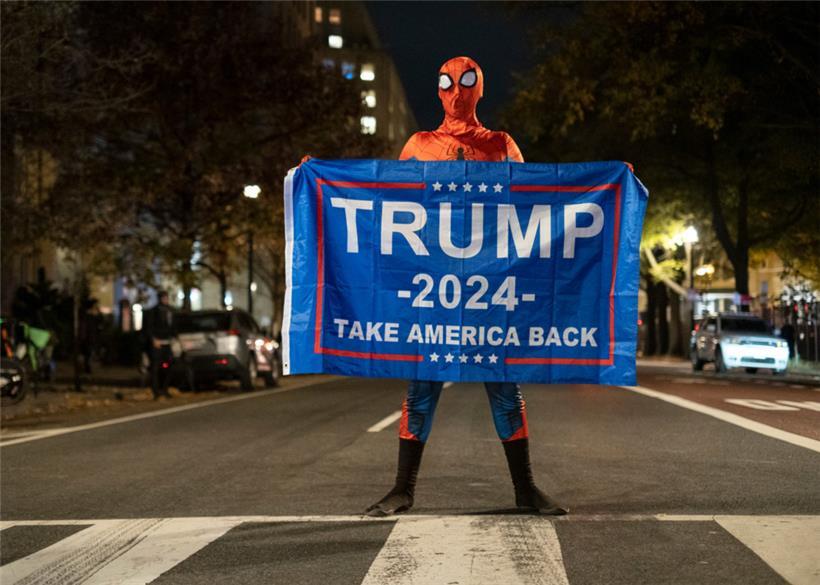 Ein Trump-Unterstützer im Spider-Man-Kostüm steht mit einem Transparent für Trump auf einer Straße in der Nähe des Weißen Hauses in der US-Wahlnacht
