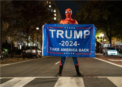 Ein Trump-Unterstützer im Spider-Man-Kostüm steht mit einem Transparent für Trump auf einer Straße in der Nähe des Weißen Hauses in der US-Wahlnacht
