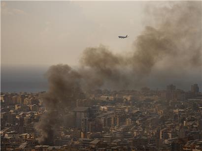 Verkehrsflugzeug landet am Flughafen Beirut, während Rauch von israelischen Luftangriffen auf südlichen Vorort aufsteigt