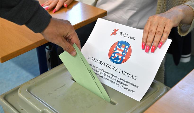 Ein Wähler steckt den Stimmzettel in die Wahlurne in einem Wahllokal in der Erfurter Innenstadt
