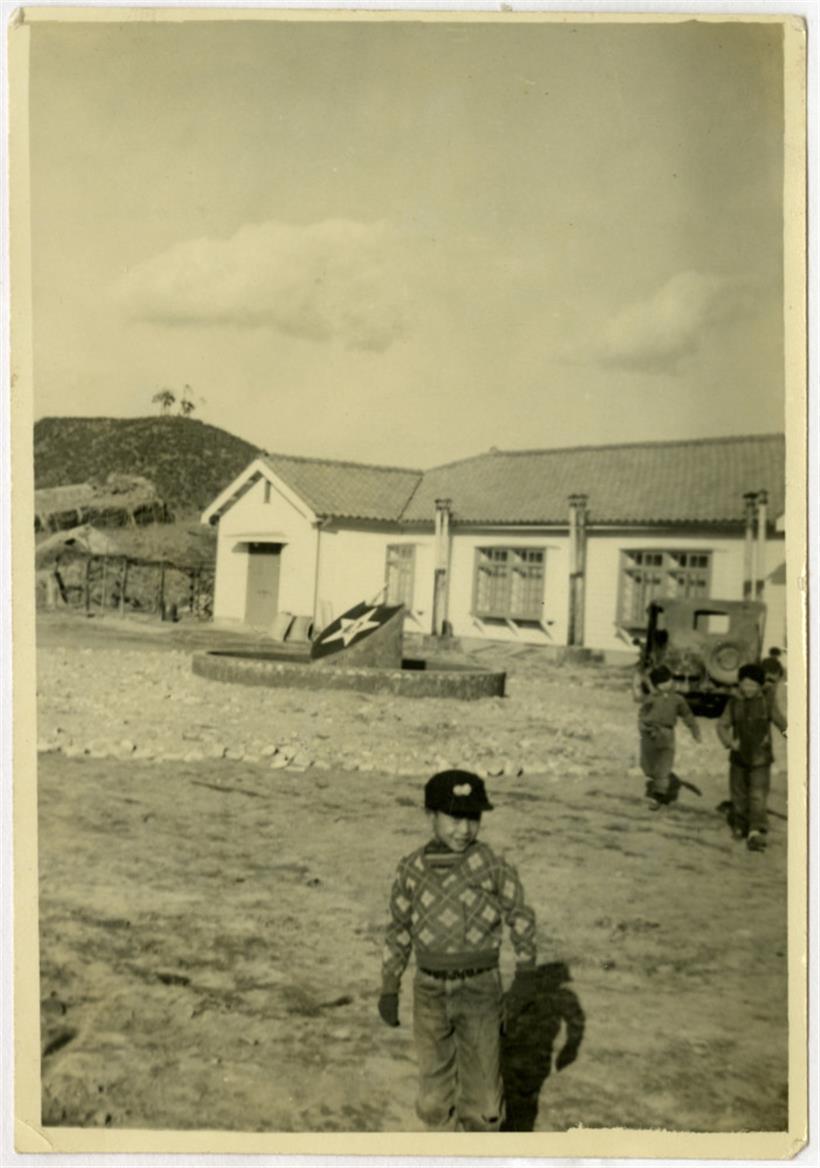 Ein Waisenkind steht vor einem Heim, das in Korea gebliebene US-Soldaten der „2nd Infantry Division“ bauen ließen (Courtesy of Tennessee State Library and Archives, David Franklin Brock (image has been altered from the original)
