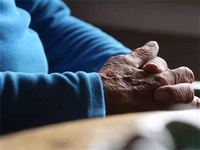 Ein älterer Mann sitzt in seiner Wohnung