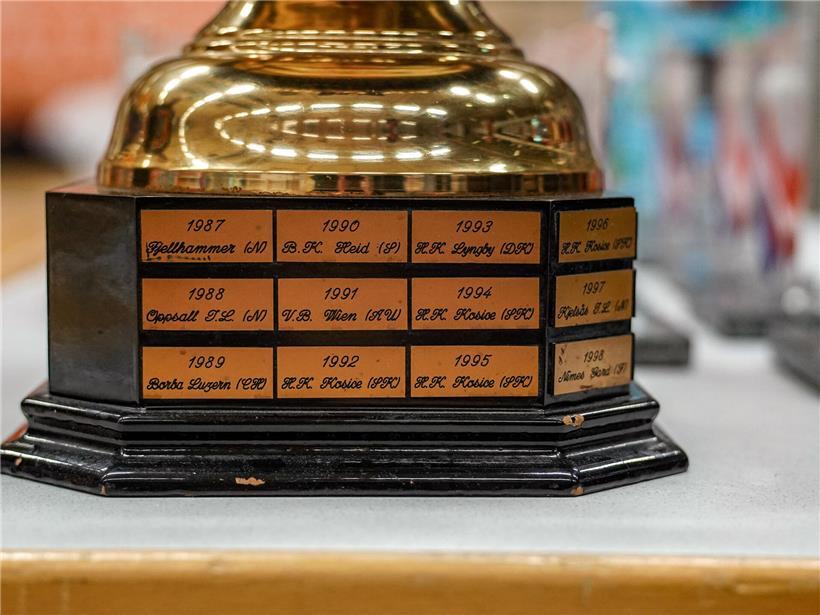 Detaillierte Aufnahme einer glänzenden Trophäe mit eingravierten Namen ehemaliger Sieger im Sportwettbewerb