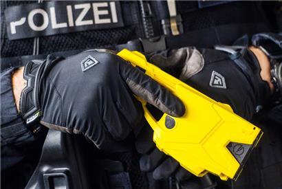 Ein deutscher Polizeibeamter hält eine Elektroschockpistole
