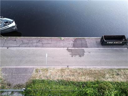 Ein dunkler Wasserfleck auf dem Pier des Hafens markiert den Ort, an dem ein Auto nach der Bergung aus dem Hafenbecken abgestellt wurde
